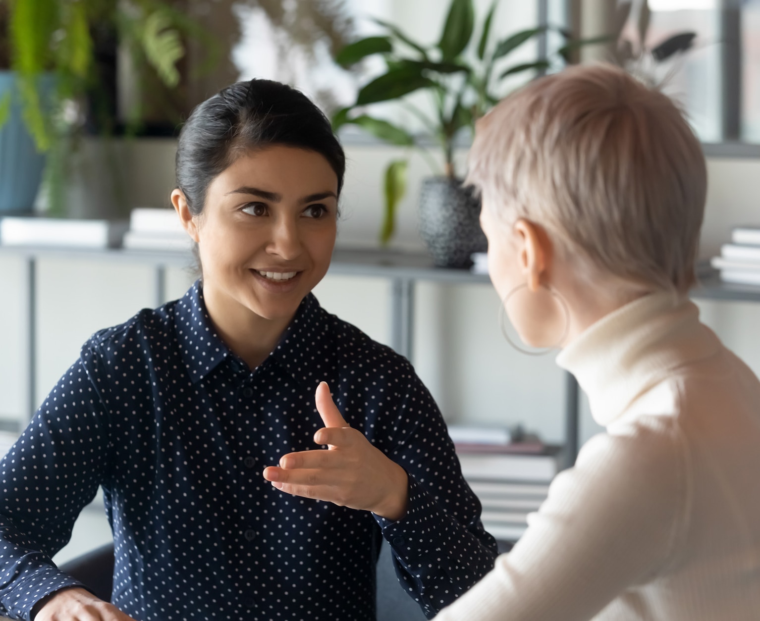 A friendly indian businesswoman talking to a blonde female A friendly indian businesswoman talking to a blonde female